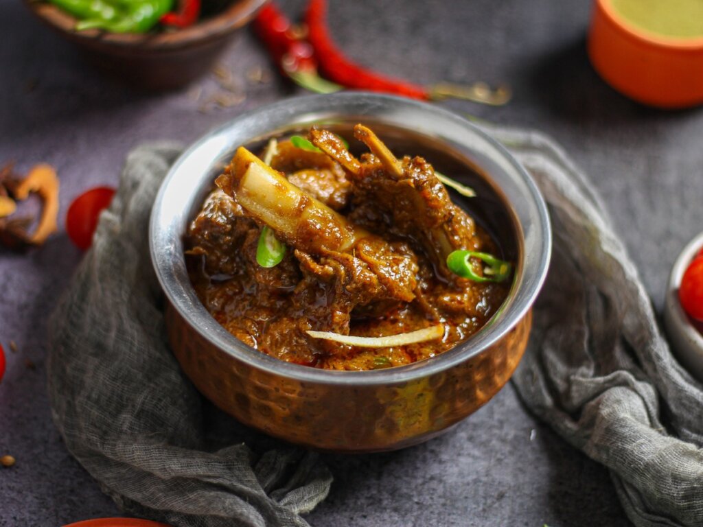 বাঙালি স্টাইলে মাটন কোষা রেসিপি: সহজ পদ্ধতি ও ঘরোয়া টিপস বাঙালি মাটন কোষা - তামার পাত্রে পরিবেশিত মশলাদার মাটন তরকারি